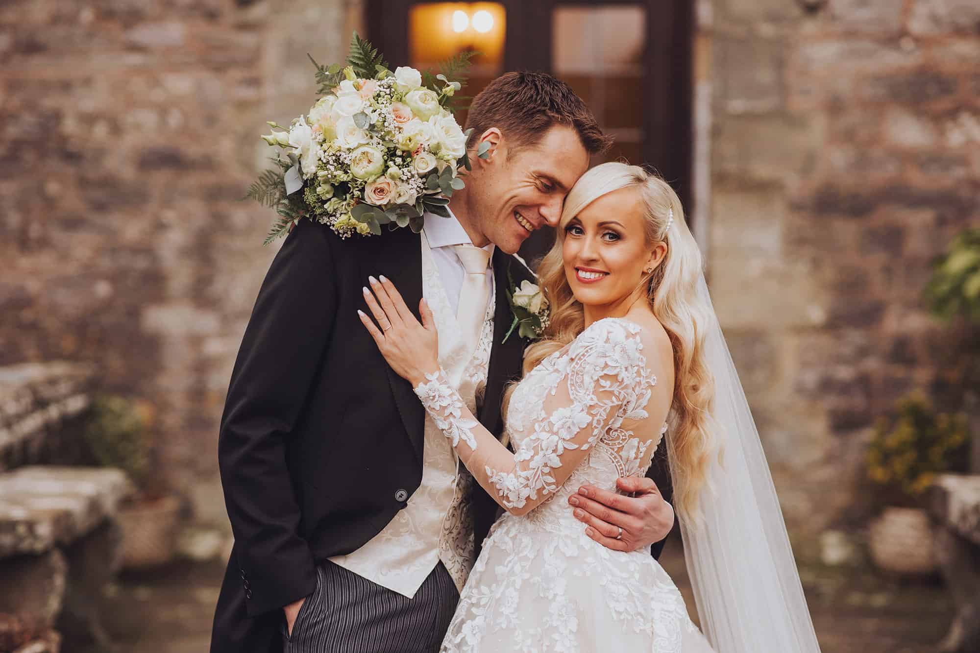 wedding couple pose in front of clearwell castle in december