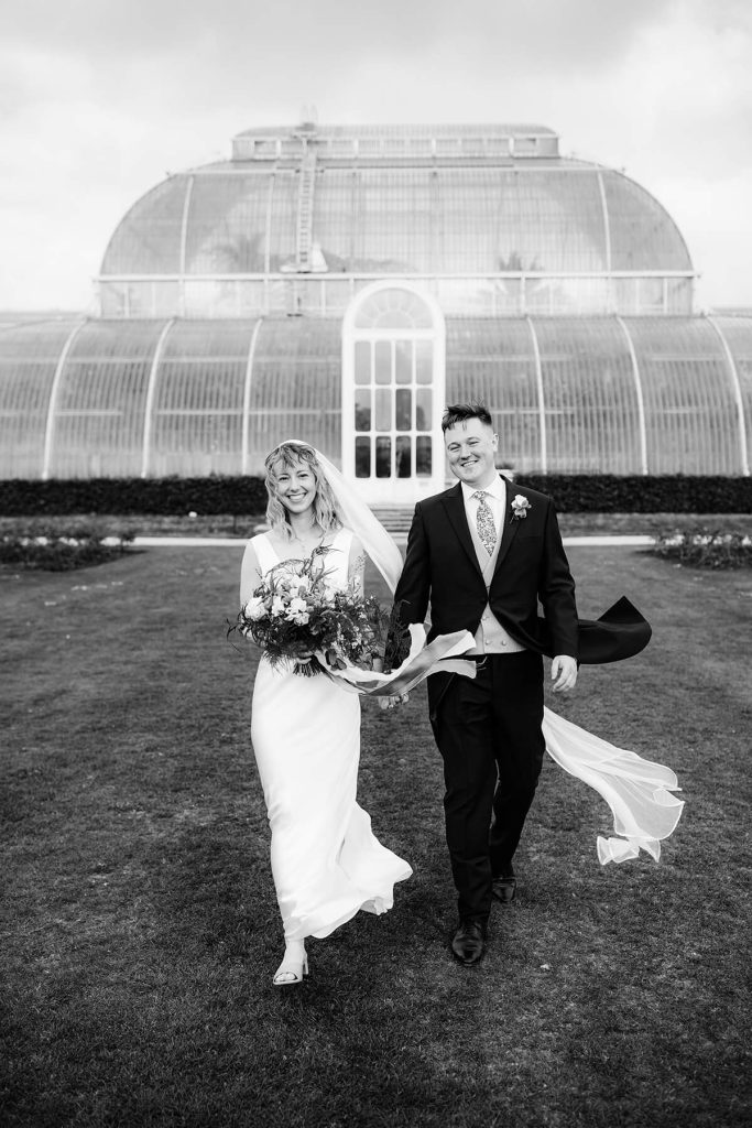 wedding couple walking outside kew gardens conservatory