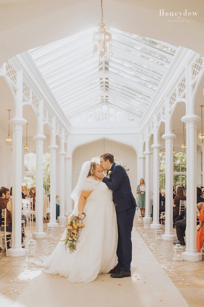 bride and groom kiss in the orangery at st audries park